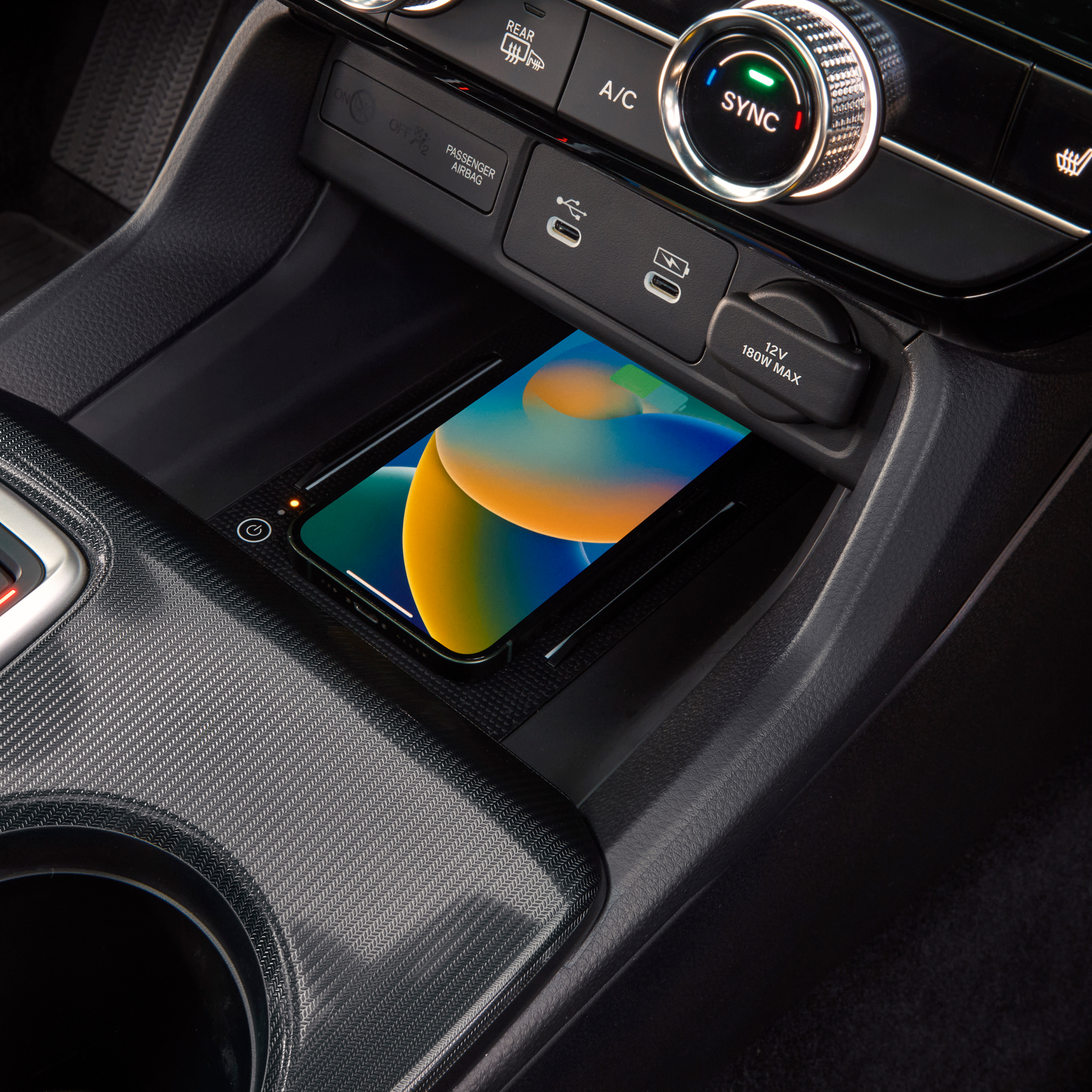 Close up of a phone wirelessly charging inside the Civic Hybrid.